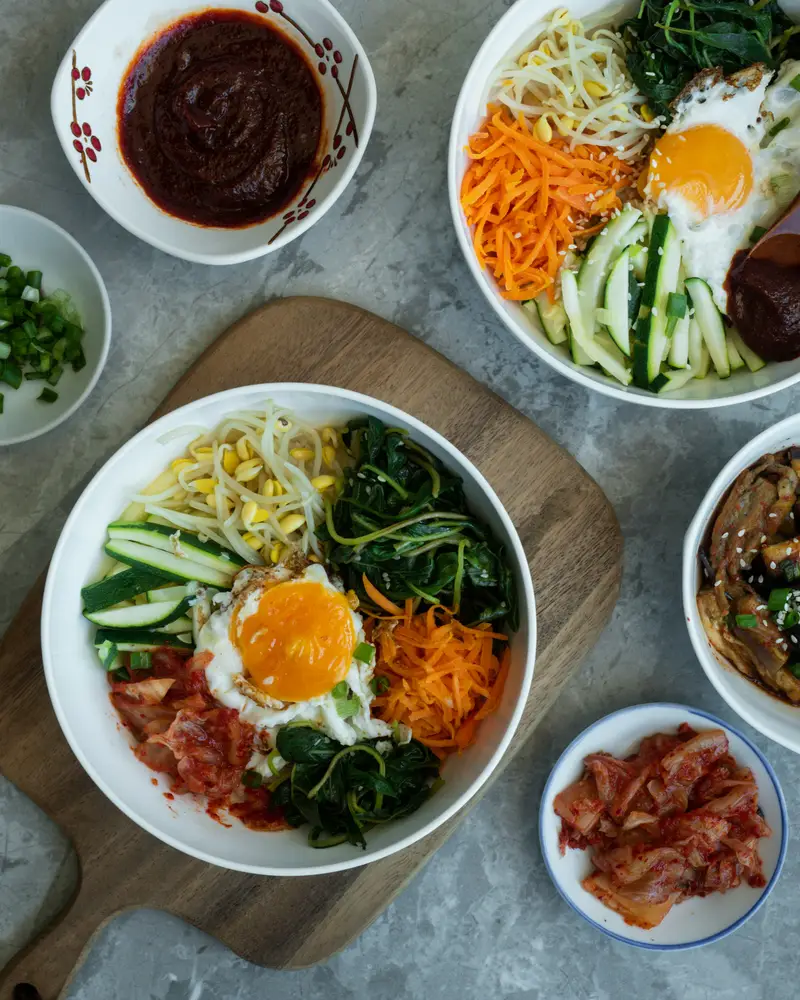 나물과 달걀 프라이를 올린 비빔 솥밥 두 그릇